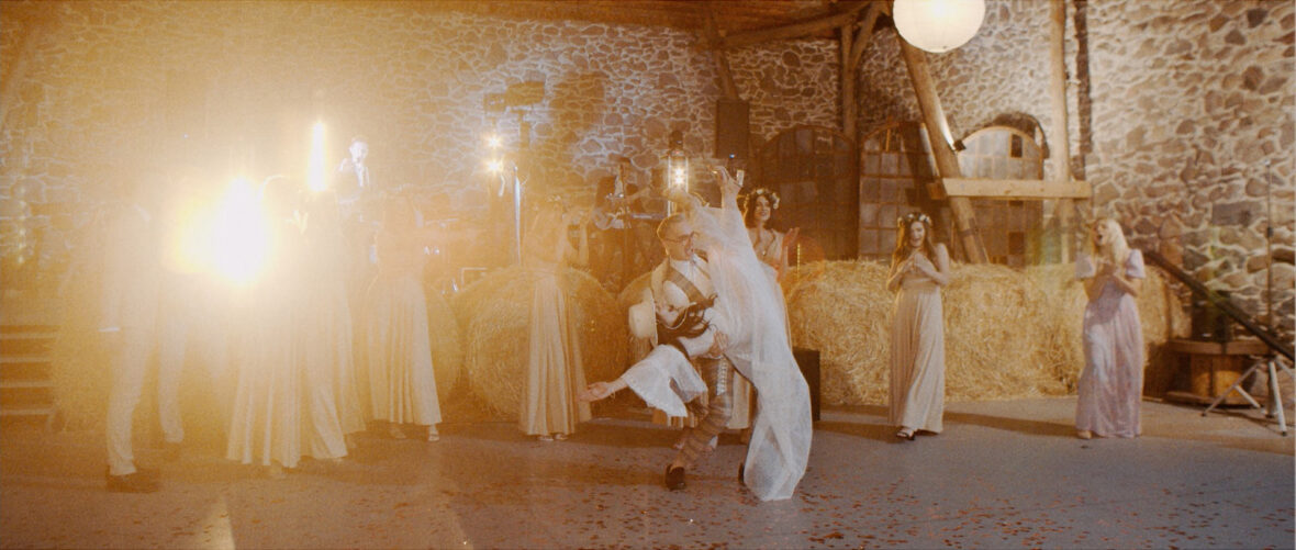 Urocza para młoda tańczy swój pierwszy taniec w stodole w stylu boho.